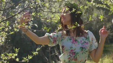 Genç ve güzel bir kadın çiçek açan erik ağaçlarında selfie çekiyor..