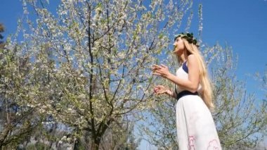 Genç ve güzel bir kadın çiçek ağaçlarının kokusunu alır..
