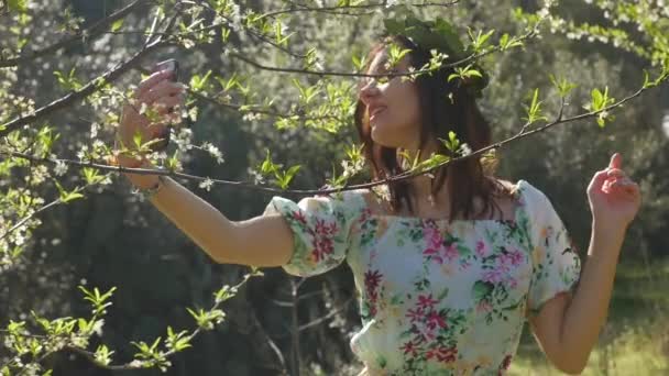Junge schöne Frau macht Selfie in blühenden Pflaumenbäumen. — Stockvideo