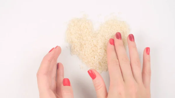 Forming heart shape from white rice — Stock Photo, Image