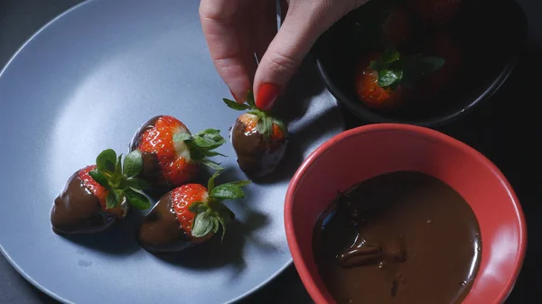Dipping strawberry into chocolate mixture — Stock Photo, Image