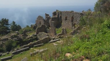 Arka planda sakin Akdeniz ile antik kale kalıntıları güzel görünümü.