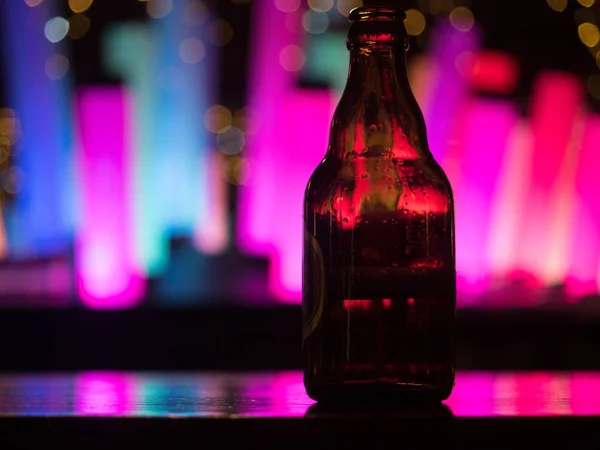 Ciemna szklana butelka piwa na liczniku bar — Zdjęcie stockowe