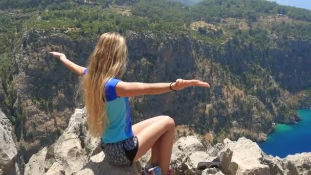 युवा महिला स्वतंत्रता का आनंद ले रही है और तुर्की में पृष्ठभूमि पर तितली घाटी के सुंदर दृश्य के साथ सूर्य स्नान कर रही है — स्टॉक वीडियो
