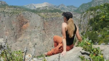 Dağın tepesinden Kelebekler Vadisi'nin güzel manzarasının keyfini çıkaran kadın gezgin