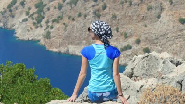 Joven mujer disfrutando de la libertad y tomando el baño de sol con beatiful viewn de Butterfly Valley en el fondo en Turquía — Vídeos de Stock
