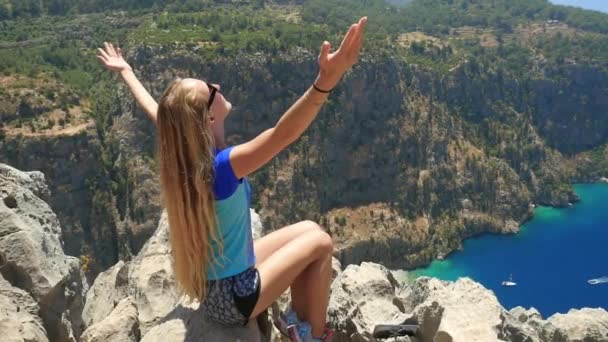 Joven mujer disfrutando de la libertad y tomando el baño de sol con beatiful viewn de Butterfly Valley en el fondo en Turquía — Vídeo de stock