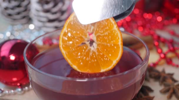 Adding slice of orange to glogg, traditional winter Baltic and Scandinavian country drink — Stock Video