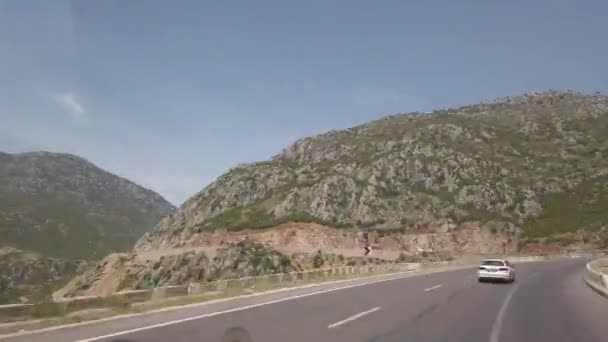 A conduzir na estrada da montanha. Vista da cabana do carro. Reflexão vista montanha na janela — Vídeo de Stock