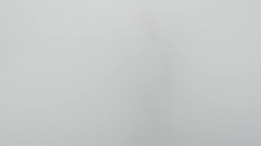 Beyaz sis ya da su buharından bir adam geliyor.