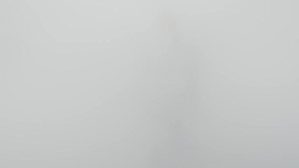 Людина, що проходить через білий туман або водяну пару — стокове відео