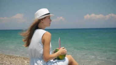 Sahilde taze meyve kokteylleri içme beyaz şapkalı genç güzel Avrupa kız