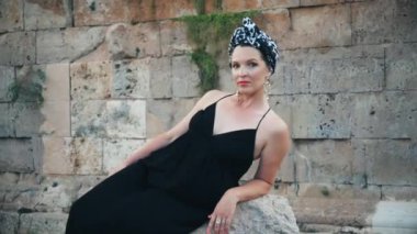 Hıdırlık kulesinin köşesinde duran uzun siyah elbiseli güzel genç çekici Müslüman kadın, tarihi yer
