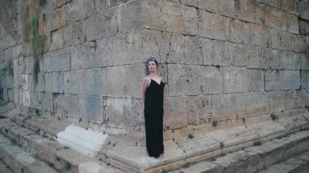Όμορφη νεαρή ελκυστική μουσουλμανική γυναίκα σε μακρύ μαύρο φόρεμα στέκεται στη γωνία του Πύργου Hidirlik, ιστορικό μέρος — Αρχείο Βίντεο
