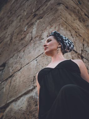 Hıdırlık kulesinin köşesinde duran uzun siyah elbiseli güzel genç, çekici Müslüman kadın