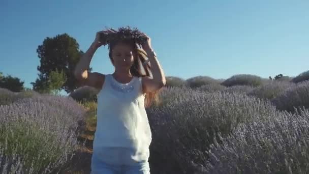 Giovane donna in abiti casual che cammina gioiosamente nel campo di lavanda — Video Stock