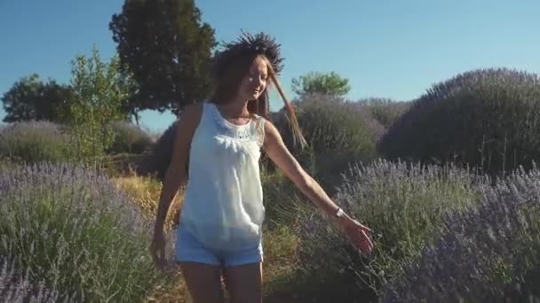 Молодая женщина в повседневной одежде ходит по лавандовому полю — стоковое видео