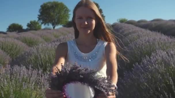 Giovane donna che tiene e guarda attraverso la ghirlanda di lavanda — Video Stock