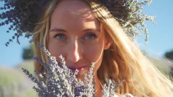 Jonge vrouw in krans met lavendel boeket — Stockvideo