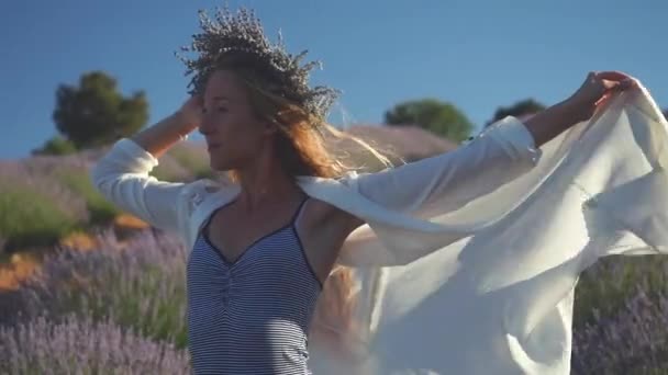 Jeune femme en couronne debout magnifiquement dans le champ de lavande — Video