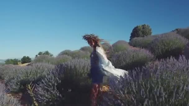 Junge Frau im Kranz spaziert in Lavendelfeld — Stockvideo
