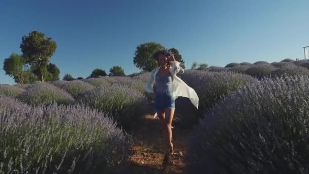 Jeune femme en couronne marchant vite comme un modèle dans un champ de lavande — Video