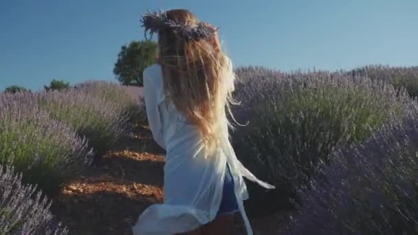 Young woman in wreath happily running in lavender field — Stock Video