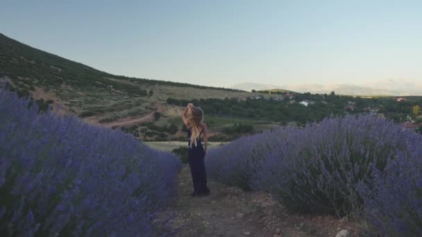 穿着休闲装的年轻女子站在薰衣草地里 — 图库视频影像