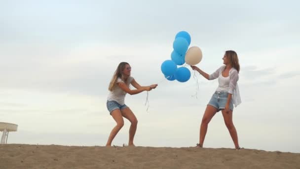 Две девушки сражаются за воздушные шары — стоковое видео