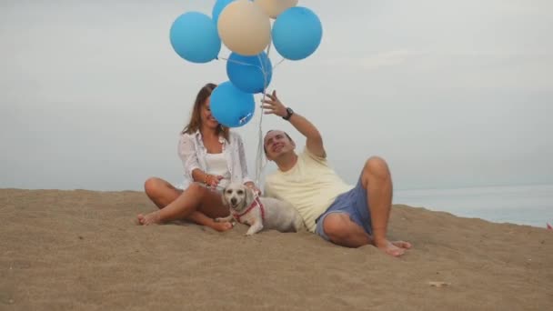 Молода пара з собакою з повітряними кулями — стокове відео