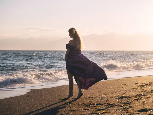 若いです女性でドレス単独で海によって歩く — ストック写真