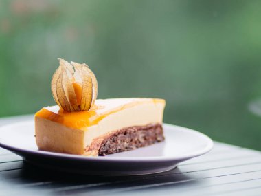 Yeşil bokeh arka plandaki tabakta lezzetli şeftalili kekin yakın çekimi.