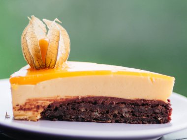 Yeşil bokeh arka plandaki tabakta lezzetli şeftalili kekin yakın çekimi.