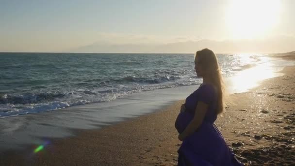 Jovem mulher de vestido andando sozinha junto ao mar — Vídeo de Stock
