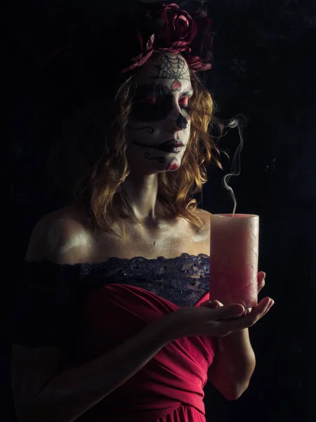 Santa muerte makeup young woman holding burning candle — Stock Photo, Image