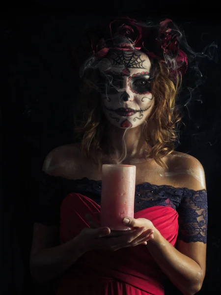 Santa muerte makeup young woman holding burning candle — Stock Photo, Image