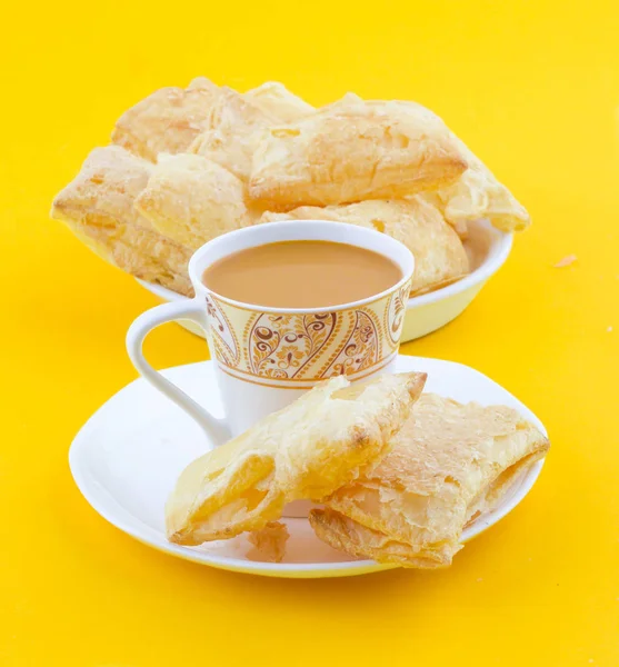 Indian Tea Time Breakfast Khari Also Know as Kharee, Khari Biscuit or Salty Puff Pastry Snacks, Served with Indian Hot Masala Chai or Hot Tea on Yellow Background