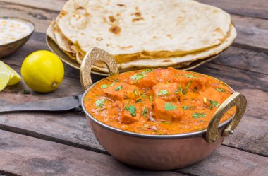 Hint Lezzetli Mutfağı Paneer Paneer Tikka Masala ve Tandoori Chapati ayrıca Paneer Butter Masala olarak da bilinir Tahta Arkaplanda Baharatlı Peynir ile servis edilen Hint Tabağı.