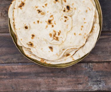 Hint mutfağı tandır Roti servis tabağına Çapati, gözleme, Naan ya Nan ekmek de denilen ahşap arka plan üzerinde