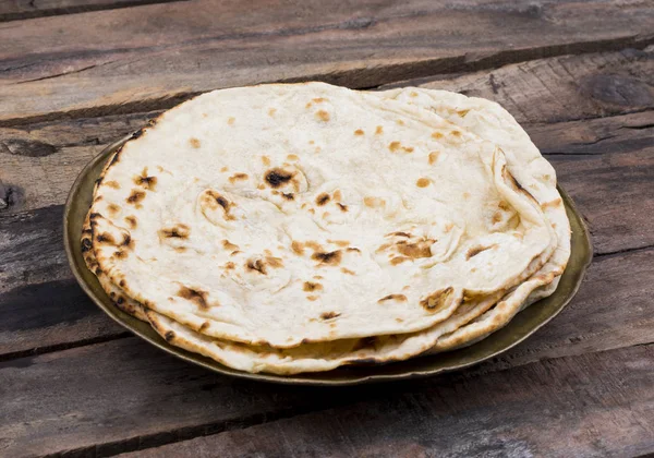 Hint mutfağı tandır Roti servis tabağına Çapati, gözleme, Naan ya Nan ekmek de denilen ahşap arka plan üzerinde