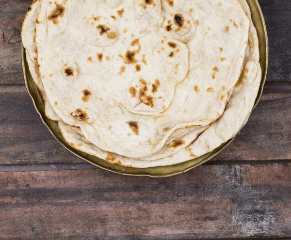 Hint mutfağı tandır Roti servis tabağına Çapati, gözleme, Naan ya Nan ekmek de denilen ahşap arka plan üzerinde