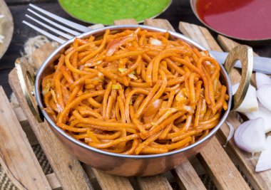 Baharatlı Kızarmış Sebze Chow Mein, Yeşil ve Kırmızı Chutney ile servis edilir ayrıca Erişte veya Hakka Eriştesi olarak da bilinir.