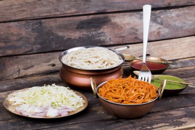 Baharatlı Kızarmış Sebze Chow Mein, Yeşil ve Kırmızı Chutney ile servis edilir ayrıca Erişte veya Hakka Eriştesi olarak da bilinir.