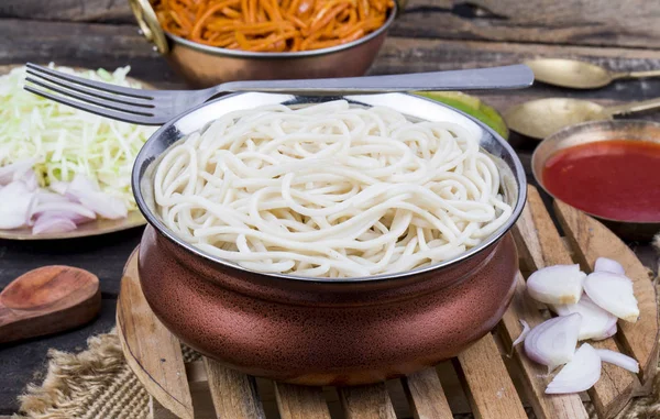 Haşlanmış Chow Mein veya Hakka Erişteleri Ahşap Arkaplanda Chutney ile servis edilir