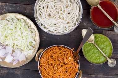 Baharatlı Kızarmış Sebze Chow Mein, Yeşil ve Kırmızı Chutney ile servis edilir ayrıca Erişte veya Hakka Eriştesi olarak da bilinir.