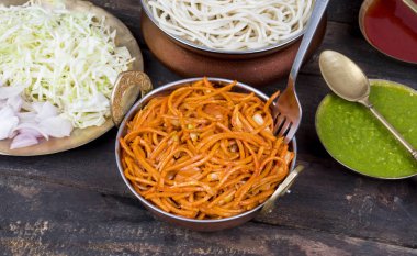 Baharatlı Kızarmış Sebze Chow Mein, Yeşil ve Kırmızı Chutney ile servis edilir ayrıca Erişte veya Hakka Eriştesi olarak da bilinir.