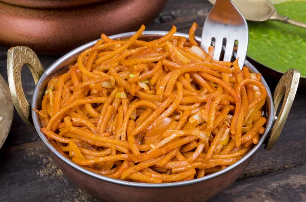 Baharatlı Kızarmış Sebze Chow Mein, Yeşil ve Kırmızı Chutney ile servis edilir ayrıca Erişte veya Hakka Eriştesi olarak da bilinir.