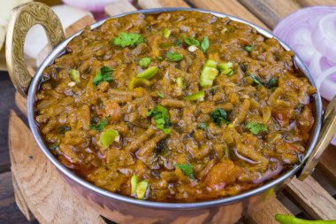 Hint mutfağı Sev Tamaeta ya da Sev Tameta da Chapati, Papad, Onion ya da Raita ile servis edilir. Domatesli ve soğan soslu, ahşap masa üzerinde baharatlı Sev soslu.