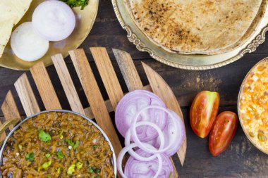 Hint mutfağı Sev Tamaeta ya da Sev Tameta da Chapati, Papad, Onion ya da Raita ile servis edilir. Domatesli ve soğan soslu, ahşap masa üzerinde baharatlı Sev soslu.