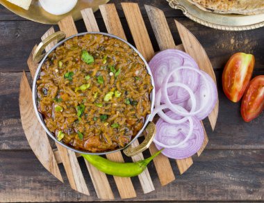 Hint mutfağı Sev Tamaeta ya da Sev Tameta da Chapati, Papad, Onion ya da Raita ile servis edilir. Domatesli ve soğan soslu, ahşap masa üzerinde baharatlı Sev soslu.